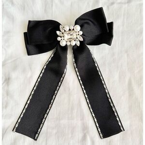 Black satin hair bow with rhinestone embellishment and pearl ￼